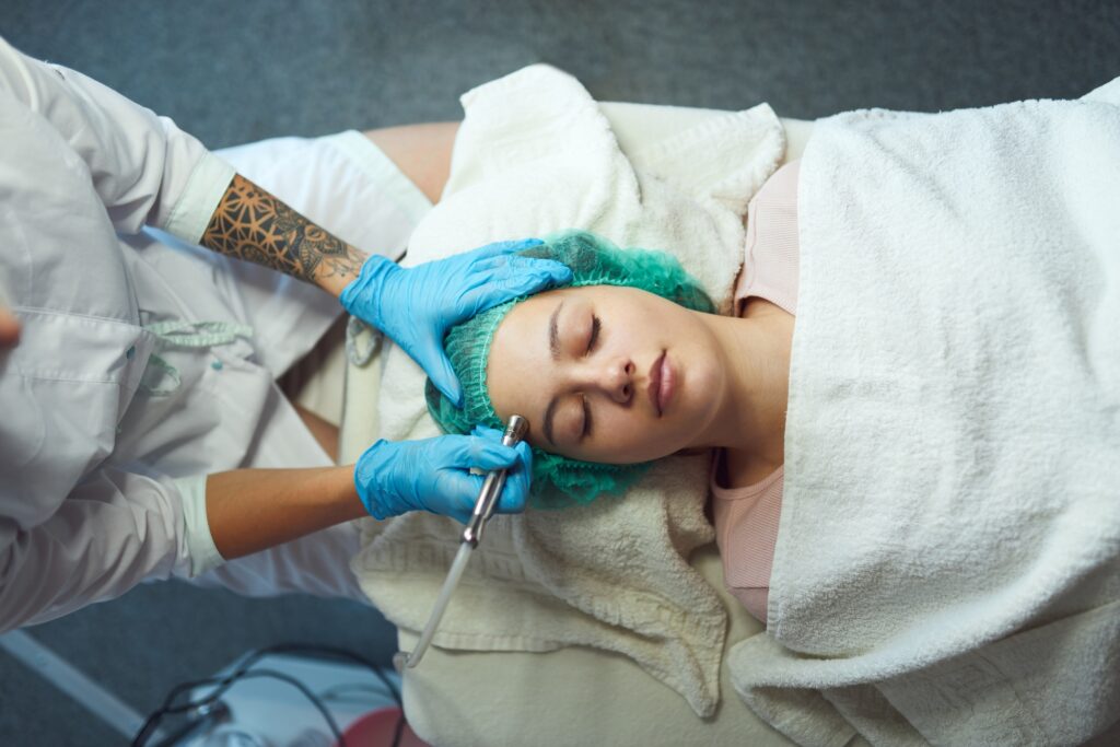 Young woman during microdermabrasion treatment in beauty salon.